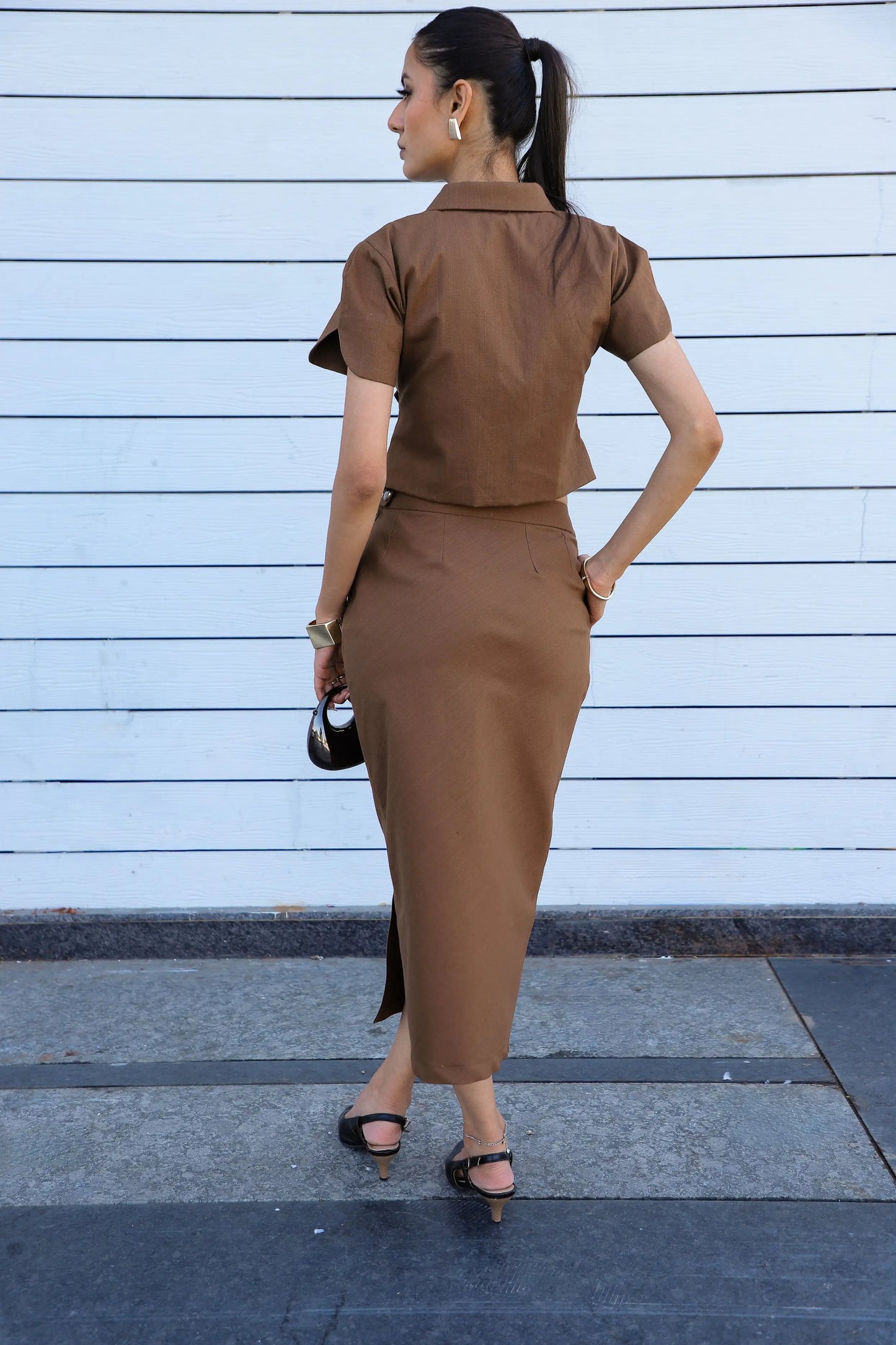 , MidWeek Women's Formal Wear - Workwear Style India, Woman in a brown outfit standing against a light blue wall.