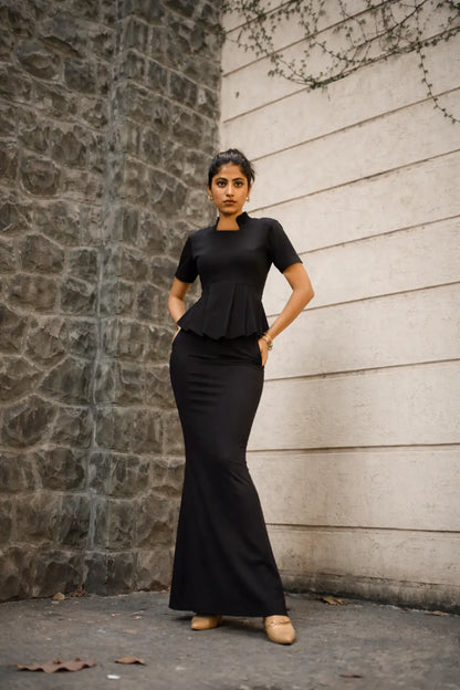 , MidWeek Women's Formal Wear - Workwear Style India, Woman wearing a black outfit standing against a stone wall.