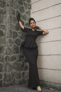 Raven Black Co-ord Set, MidWeek Women's Formal Wear - Workwear Style India, Woman in a black peplum dress standing against a stone wall.
