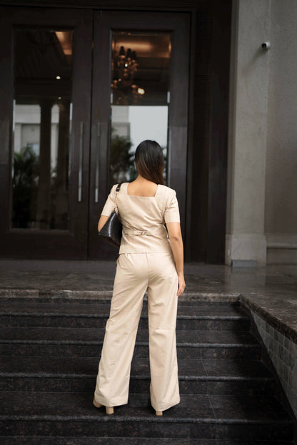 , MidWeek Women's Formal Wear - Workwear Style India, Woman in a beige jumpsuit standing on steps outside a building
