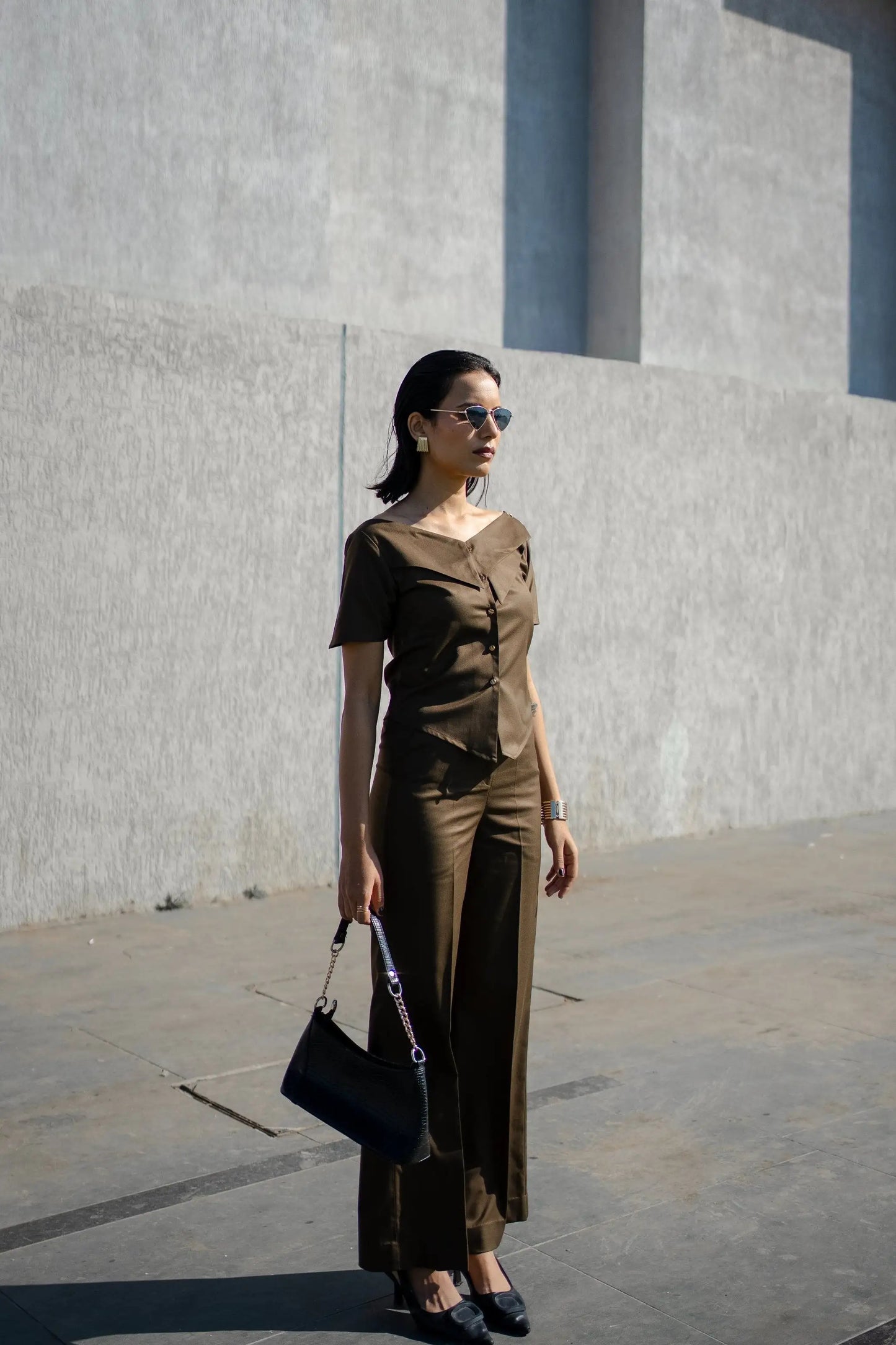 , MidWeek Women's Formal Wear - Workwear Style India, Woman in a brown outfit standing against a gray wall.